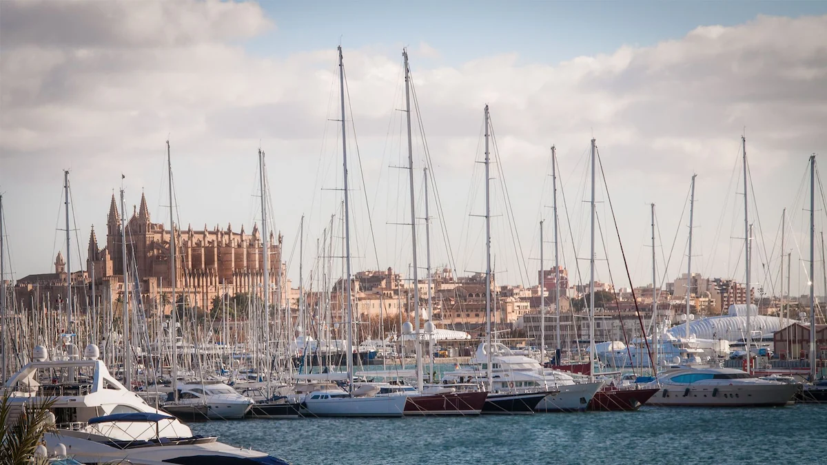 Sailboats in Palma de Mallorca marina with the cathedral behind